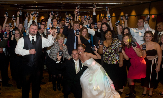 Here's another wedding party and more guests posing with their koozie favors