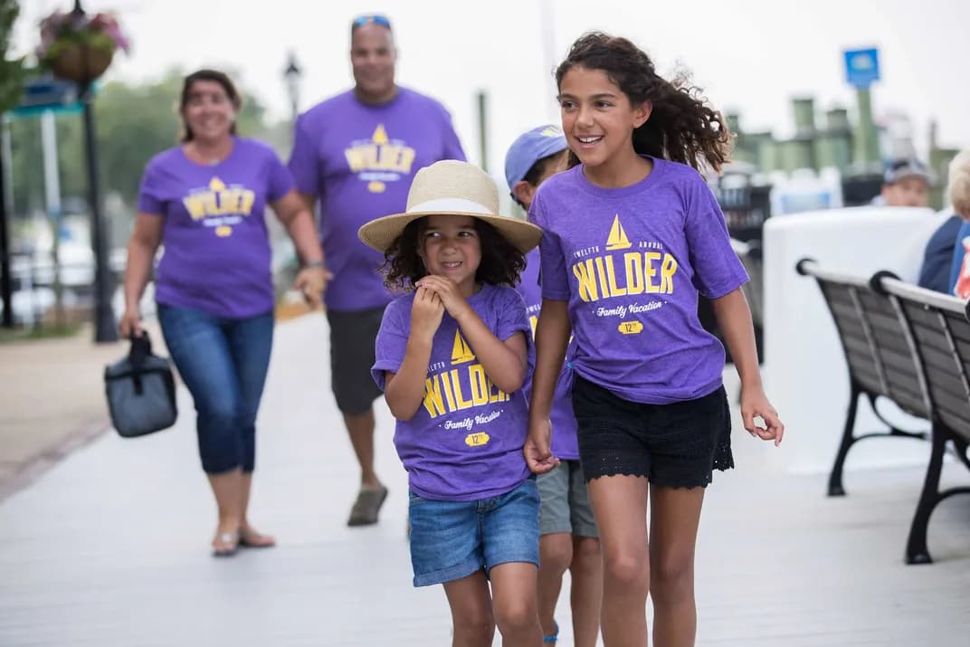 A family walks on vacation wearing matching "Wilder Family Vacation" custom t-shirts.