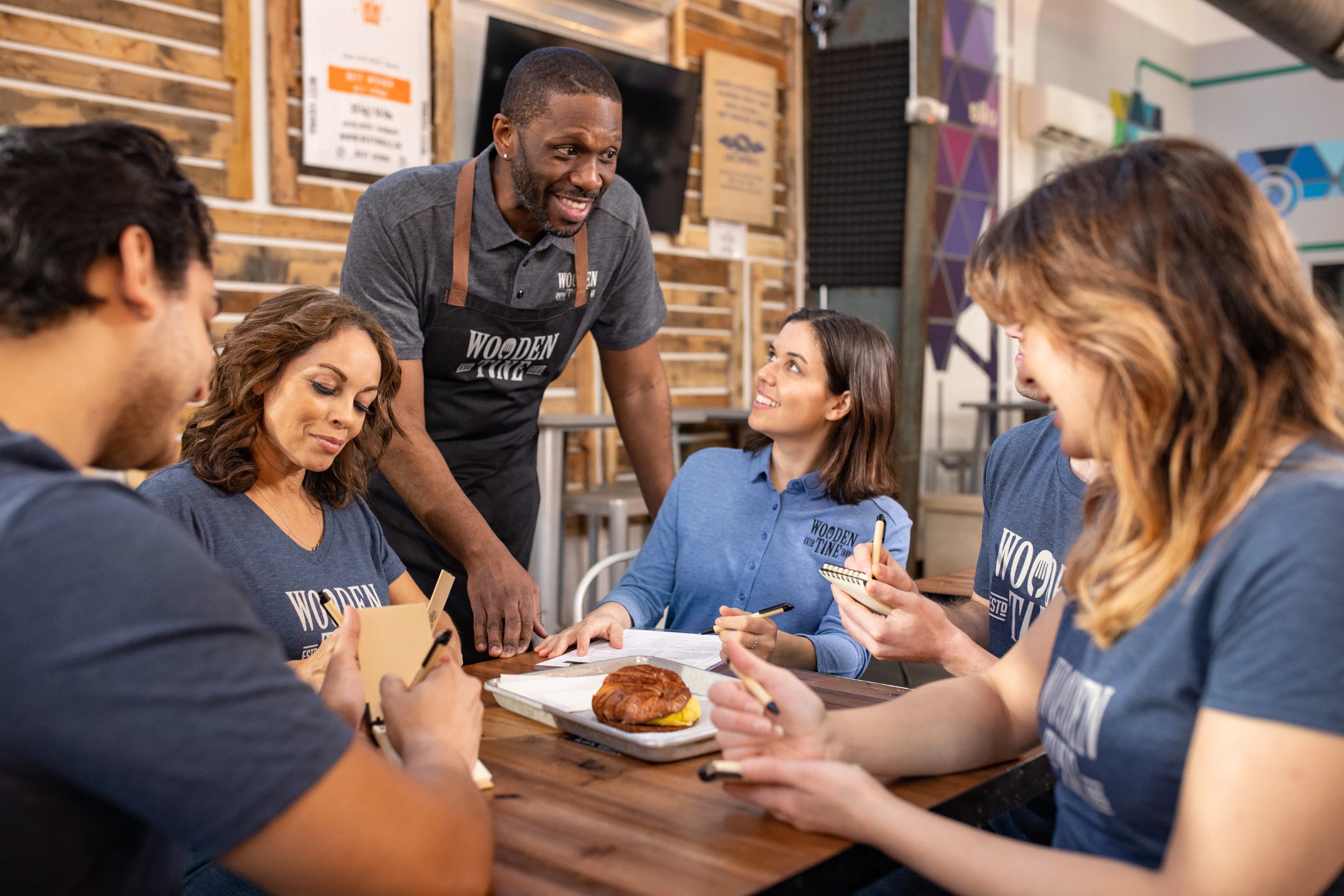 restaurant employees wearing different versions of their uniforms