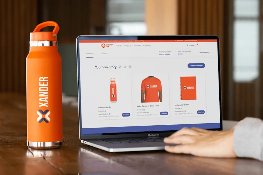 Xander branded water bottle site on table, adjacent to laptop displaying an online store for Xander branded products.