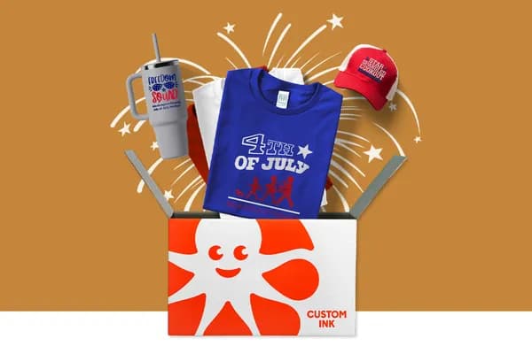4th of July custom t-shirts, tumbler, and hat coming out of a Custom Ink box.