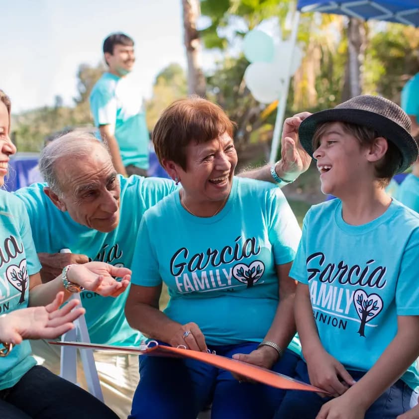 A family is laughing together while wearing matching "Garcia Family Reunion" custom t-shirts.