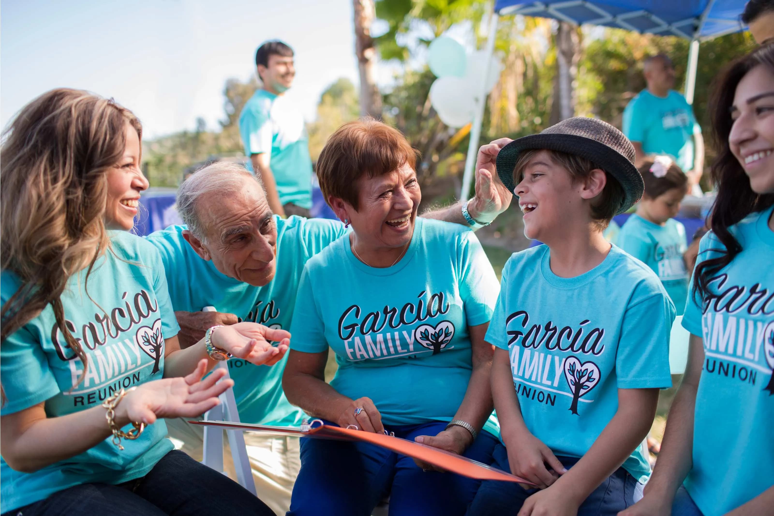A family is laughing together while wearing matching "Garcia Family Reunion" custom t-shirts.