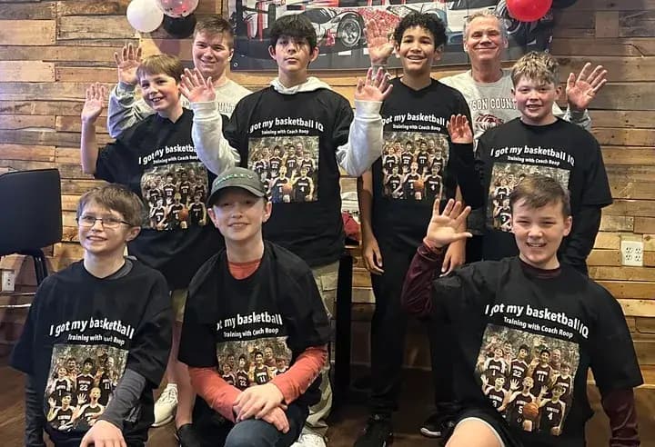 Youth basketball team wearing custom printed t-shirts celebrating training with their coach.