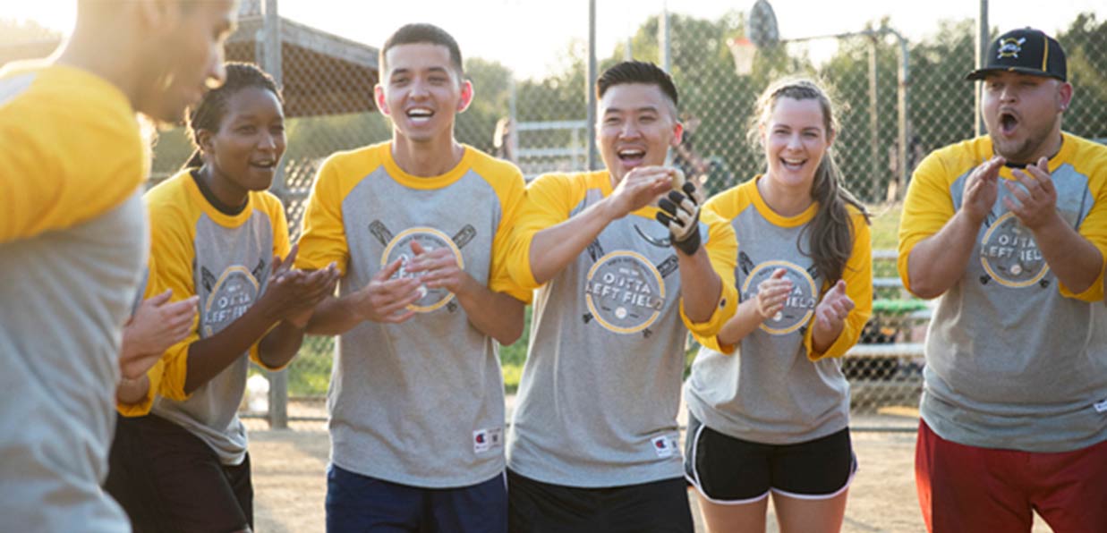 A co-ed softball team laughs and cheers each other on in custom baseball raglans.