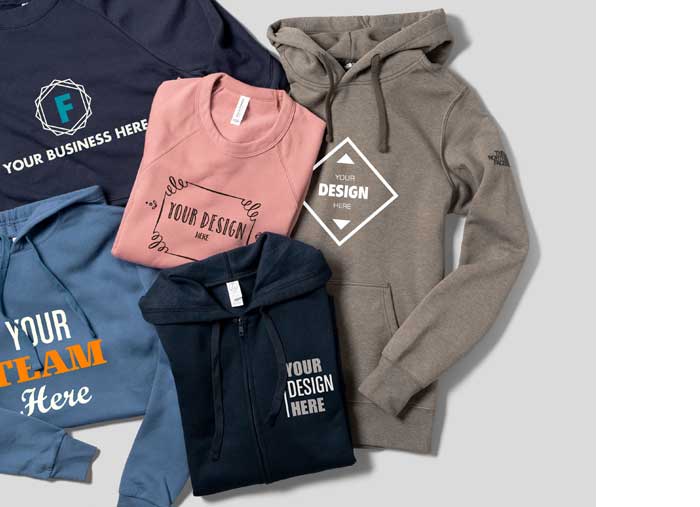 A restaurant's uniforms are displayed on a table- custom t-shirt, hat, polo, apron, and stickers.