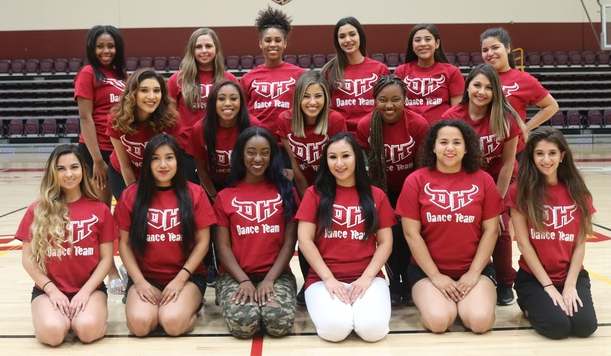 Dance team in performance uniforms with custom sayings celebrating movement and stage presence