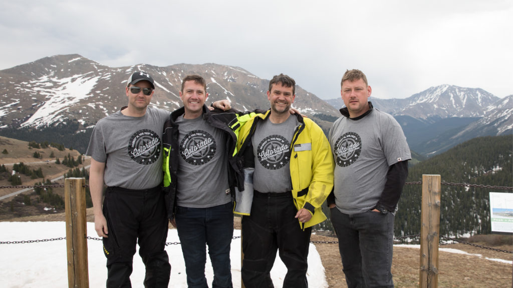 friends pose together with a mountain in the background