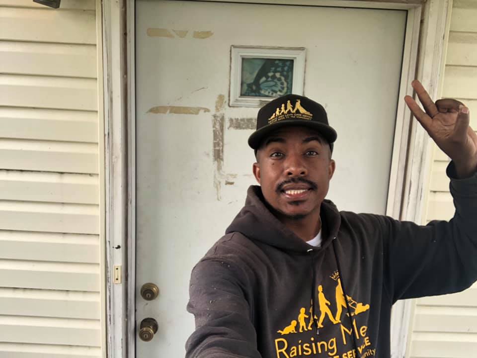 A man wearing a sweatshirt and hat bearing his custom design.