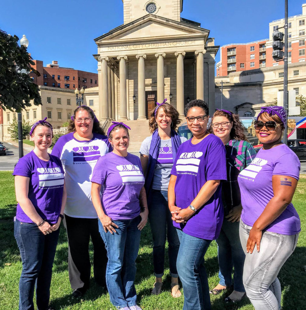 Photo of members of the DCCADV showing off their Spread Love DC shirts