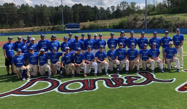 High school varsity baseball team wearing matching custom shirts for senior night on the field
