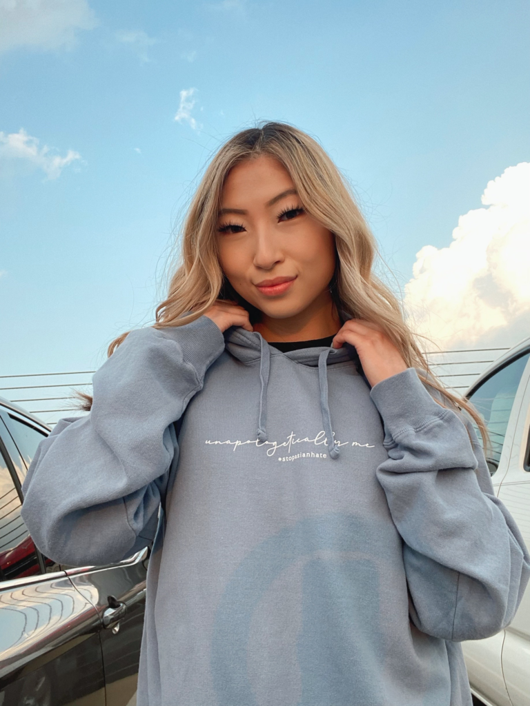 Woman wearing hoodie with 'Unapologetically Me' written on the front in script