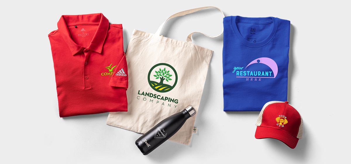 A red custom polo, a custom canvas bag, a custom water bottle, a custom t-shirt, and a custom hat.