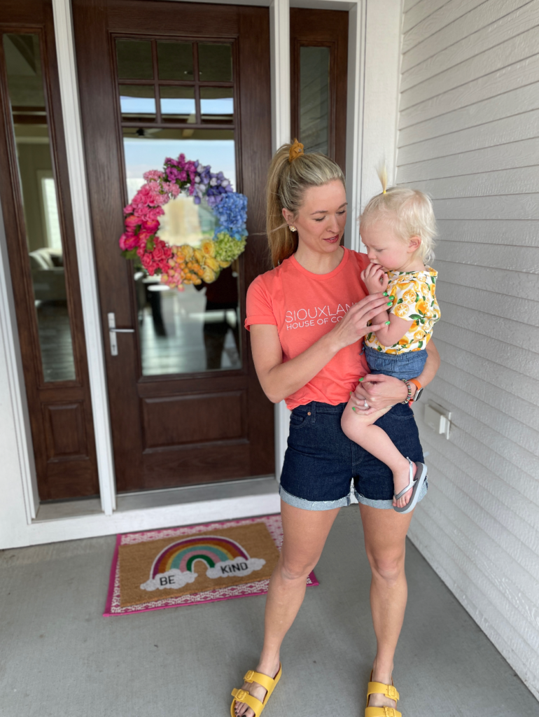 Woman in a colorful outfit holding a toddler.