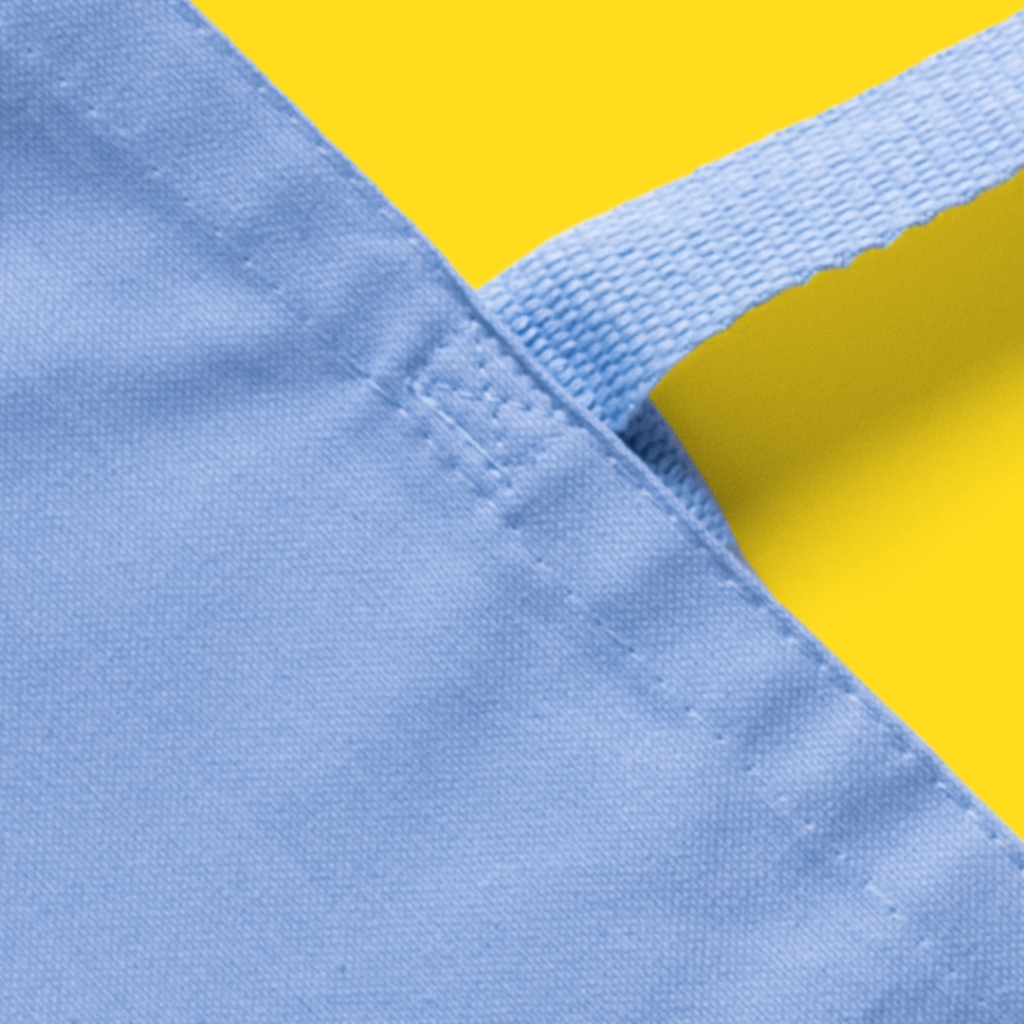 A close-up of a baby blue cotton canvas bag, showing its durable body and straps. 