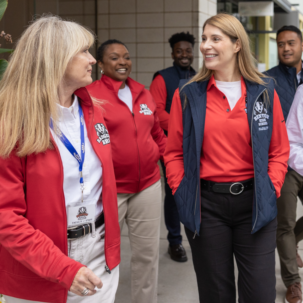 teachers and school admin walking around their school together in custom apparel