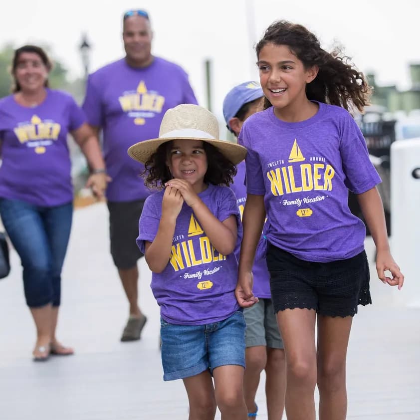 A family walks on vacation wearing matching "Wilder Family Vacation" custom t-shirts.