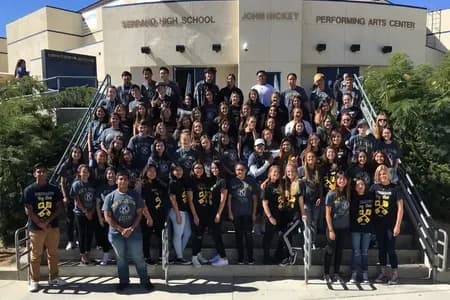 Large group of high school students wearing matching custom black and gold Key Club t-shirts on school steps.