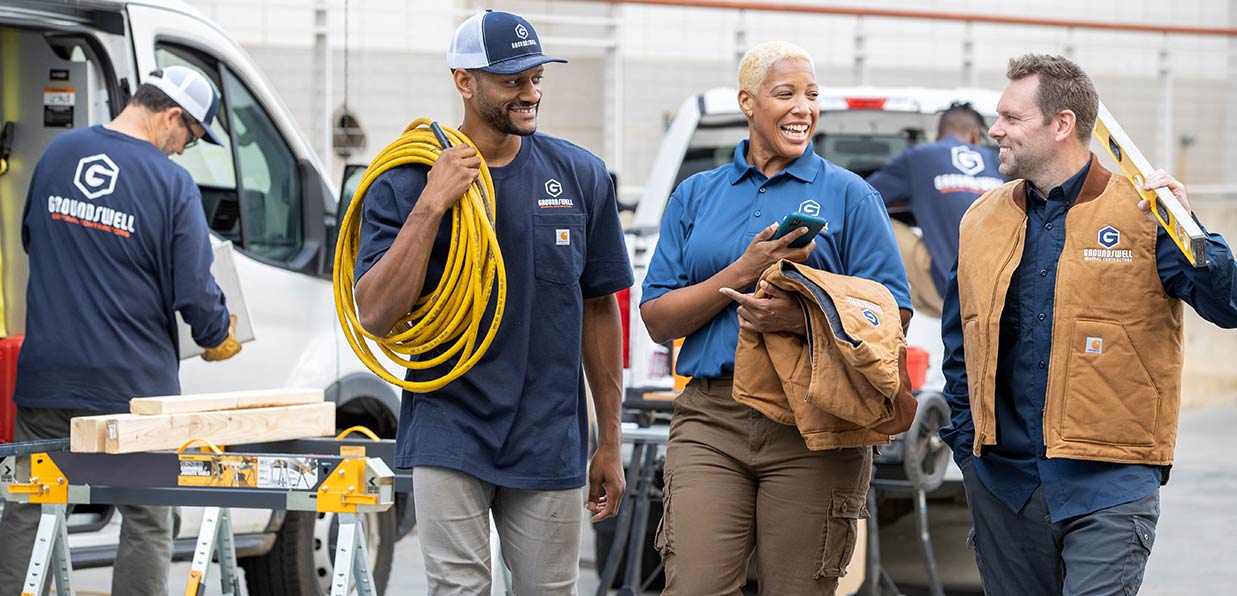 A construction team is on the job together in custom polos and Carhartt t-shirts.