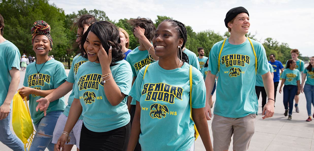 A group of seniors walk together outside in Senior Squad t-shirts.