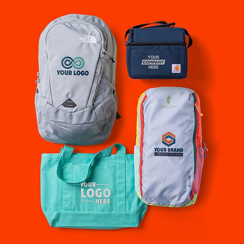 Two backpacks, a lunch bag, and a tote bag customized with logos.